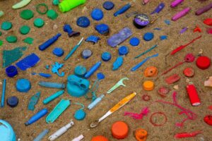 array of plastics on beach sand